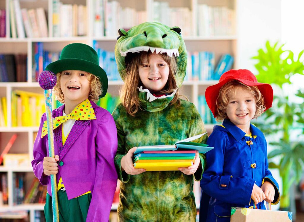 Kids in costume holding books in a bookstore