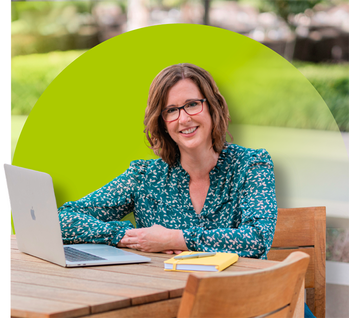 Kathy sitting at a table with a laptop open