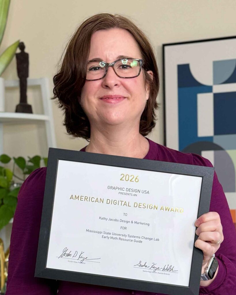Kathy is holding the award for the Early Childhood Math Guide